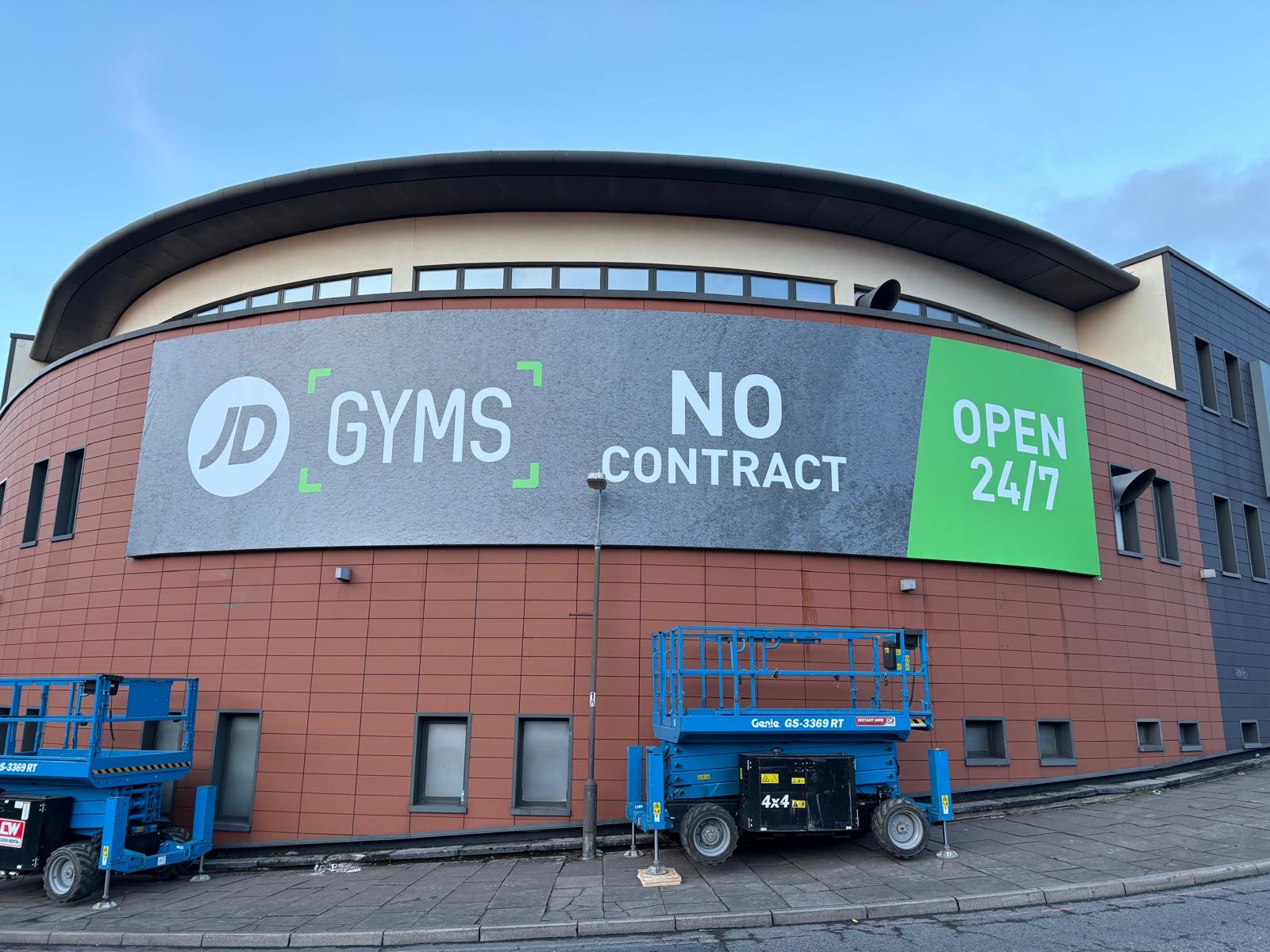 Huge 16m by 9m JD Gyms flex face sign on a curved tile wall in Birmingham